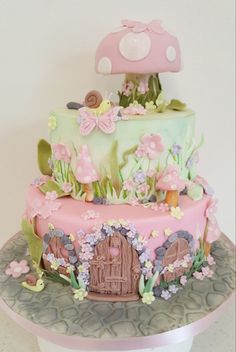 there is a cake that has flowers on the side and a house in the middle