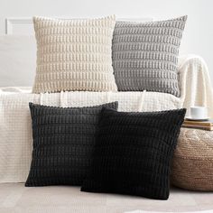 three black and white pillows sitting on top of a bed next to a pillow case