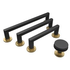 three black and gold knobs are on the handles of this set of drawer pulls