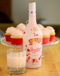 a bottle of bailey's strawberry cream next to cupcakes