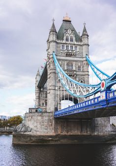 the tower bridge is very tall and has blue railings on it's sides