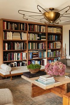 a living room filled with lots of books and furniture