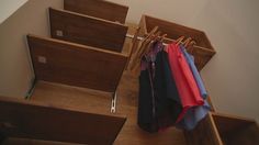 clothes hanging on wooden racks in a closet