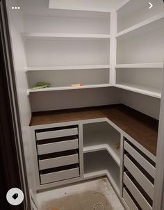 an empty white pantry with drawers and shelves