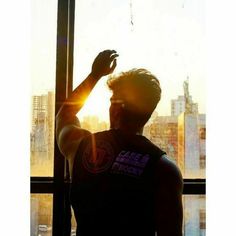 a man standing in front of a window with the sun shining down on his arm