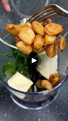 someone is adding nuts to their food in a glass bowl with cheese and spinach