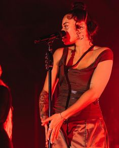 a woman singing into a microphone on stage