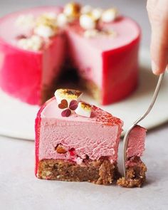 a piece of cake on a plate with a fork in it and someone taking the slice