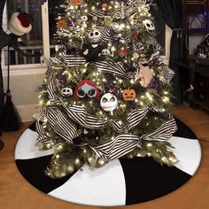 a decorated christmas tree in the middle of a living room with black and white striped decorations