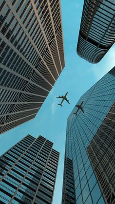 an airplane flying through the air between two tall buildings