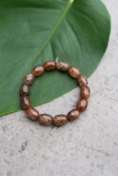 This bracelet is made of glass oval brown beads. Each of the beads are approximately 1/4" W x 1/2" L and have a beautiful design that varies by bead. A stretch bracelet that can be worn everyday and every season. A perfect gift for you or your loved ones, you will want to buy several because they look even better when stacked! Handcrafted by and sold in support of vulnerable women in Thailand. Metal Bead Bracelet, Celebrate Recovery, Men Coffee, Ceramic Tea Set, Chocolate Tea, Chain Extenders, Gaming Clothes, Pendant Rings, Metal Beads