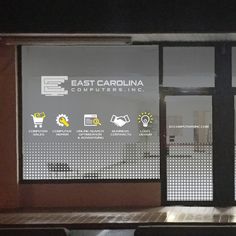 an empty bench in front of a window with the east carolina computer inc logo on it