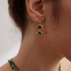 The setting is made of sterling silver, which is a popular metal choice for jewelry due to its durability and affordability. The sterling silver is then plated with a layer of gold, giving the earrings a luxurious and glamorous appearance. The gold plating adds warmth and richness to the overall design. Malachite is believed to offer emotional healing, protection from negative energies, and support personal transformation and growth. Chemical substances like perfumes, lotions, hairsprays, and cl Tarnish Resistant Sterling Silver Oval Earrings, Oval May Birthstone Earrings, Tarnish Resistant Emerald Jewelry, Chemical Substances, Personal Transformation, Green Oval, Malachite Stone, Emotional Healing, Gold Plated Sterling Silver