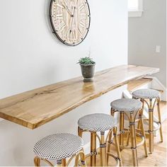 a counter with stools and a clock on the wall above it in a room