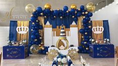 a blue and gold birthday party with balloons, table settings and decorations on the walls