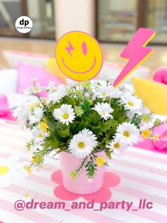 a vase filled with white daisies sitting on top of a table next to a sign that says dream and party