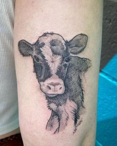 a black and white cow tattoo on the leg