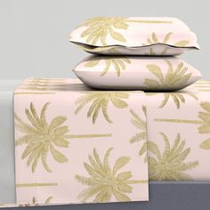 three pillows are stacked on top of each other with palm trees printed on the covers