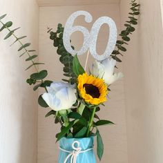 a vase filled with flowers next to a number 60 sign