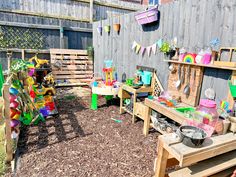 an outdoor play area with wooden benches and toys on the ground in front of a fence