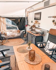 a living area with couches, chairs and a table in front of a tent