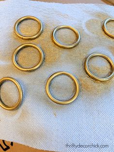 six gold rings sitting on top of a piece of cloth