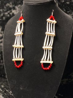 a necklace and earring set with red beads on a mannequin neckline