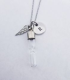 "This beautiful stainless steel memorial necklace can be personalized with your loved ones initial. The glass hourglass pendant holds ashes so you can keep your loved one close to your heart always. Each order includes a funnel and instructions for ease when filling your necklace. The chain is 18\". All parts are hypoallergenic and will never tarnish. Hourglass Cremation Necklace Angel Memorial Jewelry Cremation Memorial Necklace Urn Necklace Urn Jewelry for Ashes Personalized Necklace" Personalized Stainless Steel Necklace For Keepsake, Personalized Stainless Steel Keepsake Necklace, Customizable Stainless Steel Keepsake Necklaces, Customizable Stainless Steel Keepsake Necklace, Customizable Stainless Steel Necklace For Keepsakes, Personalized Silver Charm Necklaces For Keepsake, Personalized Silver Charm Necklace For Keepsake, Silver Stainless Steel Necklace For Remembrance, Personalized Stainless Steel Jewelry For Memorial