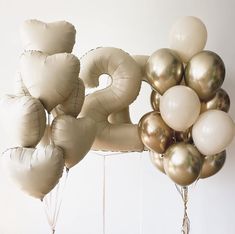 balloons are arranged in the shape of the number twenty five on a white background with gold and silver accents