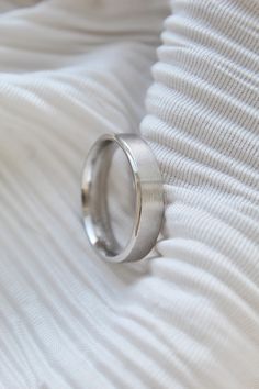 a wedding ring sitting on top of a white blanket