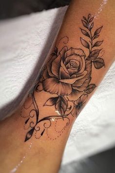 a black and white rose tattoo on the leg