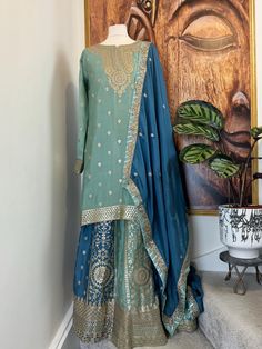 Readymade chinos sage green and blue heavy embroidered Sharara Suit, Punjabi Salwar suit. It is available for fast delivery. Indian Pakistani wedding dress Details Sharara/Salwar/Plazzo Fabric: Chinon Colour : Sage green and blur Inner: Crape lined Design: Huge flair with heavy embroidery on the Sharara Kameez/Shirt/Kurti Fabric: Chinon Colour: Sage green Inner : Crape lined Design:Heavy embroidery on neck and hem of the shirt Dupatta Fabric : Georgette Color: Sage green Design :Beautiful dupatt Transitional Green Anarkali Set With Dabka, Transitional Green Anarkali Sharara, Traditional Green Sharara For Designer Wear, Designer Green Raw Silk Sharara, Green Resham Embroidery Kurta For Transitional Season, Green Raw Silk Sharara For Diwali, Green Sharara With Dupatta For Transitional Season, Transitional Green Kurta With Resham Embroidery, Transitional Green Sharara With Dupatta