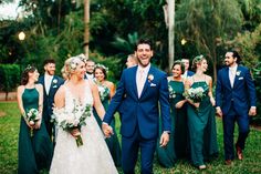 a bride and groom walking with their bridal party