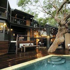 a house with a pool in the middle of it and decking area next to it