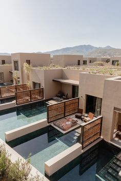 an aerial view of a house with a pool in the foreground and mountains in the background