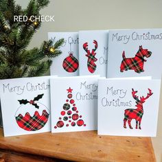 four christmas cards on top of a wooden table