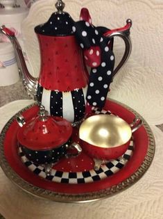 a red and black tea set sitting on top of a plate