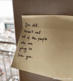 a piece of paper with writing on it hanging from the side of a window sill