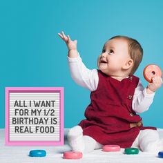 a baby sitting in front of a sign that says, all i want for my 12 birthday is real food