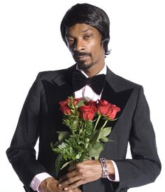 a man in a tuxedo holding roses