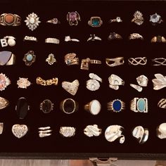 a box filled with lots of different types of rings and brooches on display