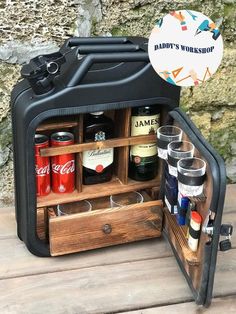 a cooler with drinks inside sitting on top of a wooden table next to a stone wall