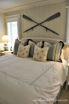 a bedroom with a large bed and two paddles mounted to the wall above it