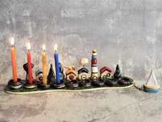 a group of candles sitting on top of a table next to a boat and lighthouse