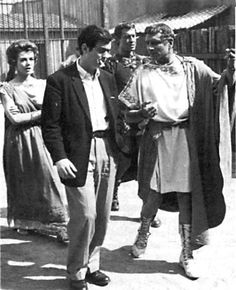 an old black and white photo of people walking down the street