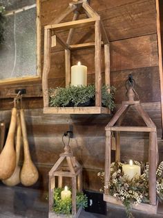 three wooden hanging lanterns with plants and candles