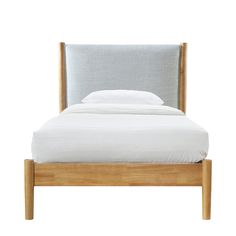 an upholstered bed with white sheets and pillows