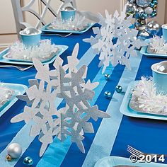 the table is set with silver and blue decorations