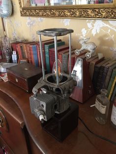 an old fashioned camera sitting on top of a table next to books and other items