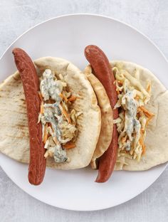 two hot dogs on pita bread with cole slaw